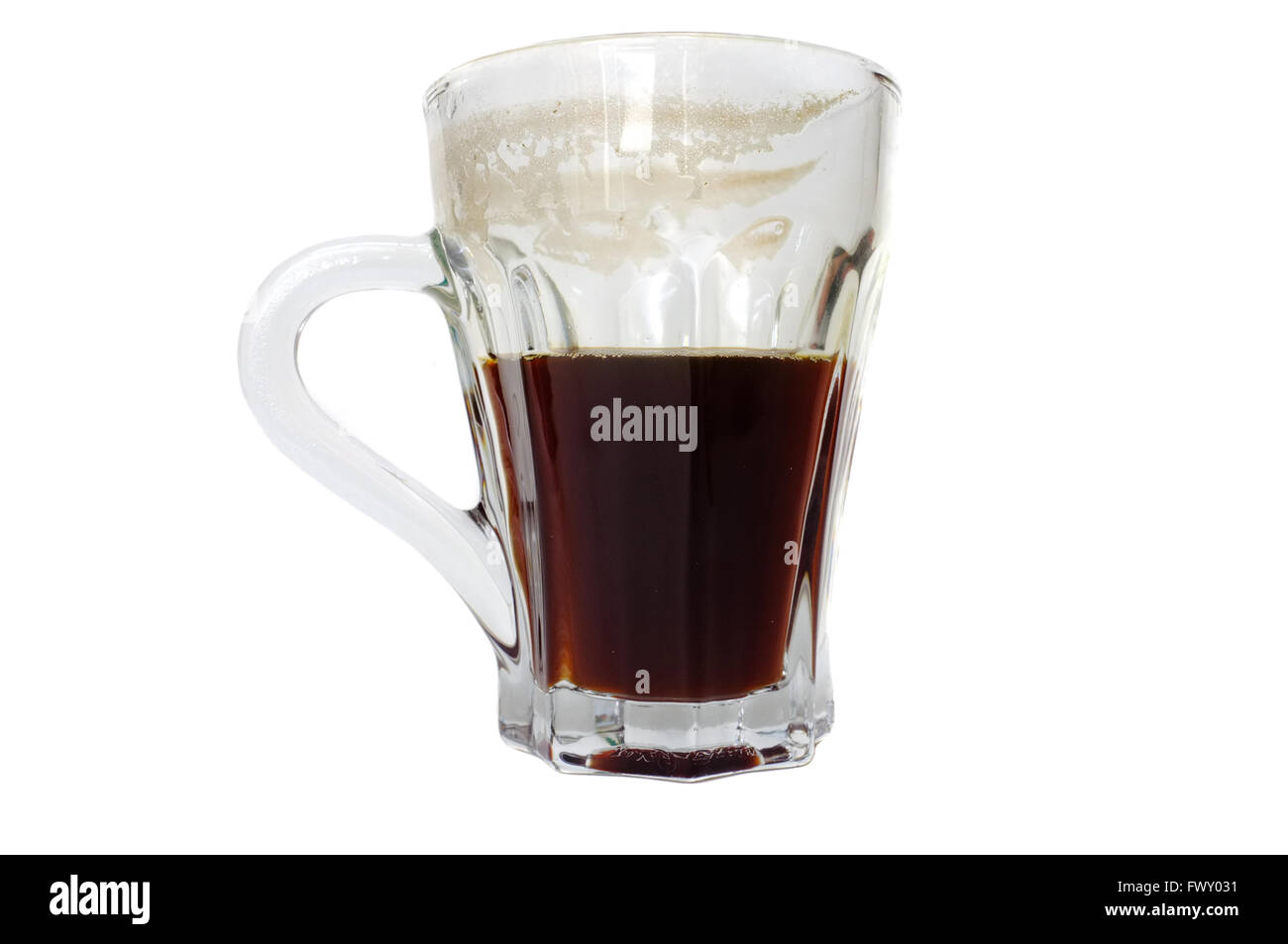 A glass coffee cup half full with black coffee photographed against a white background. Stock Photo