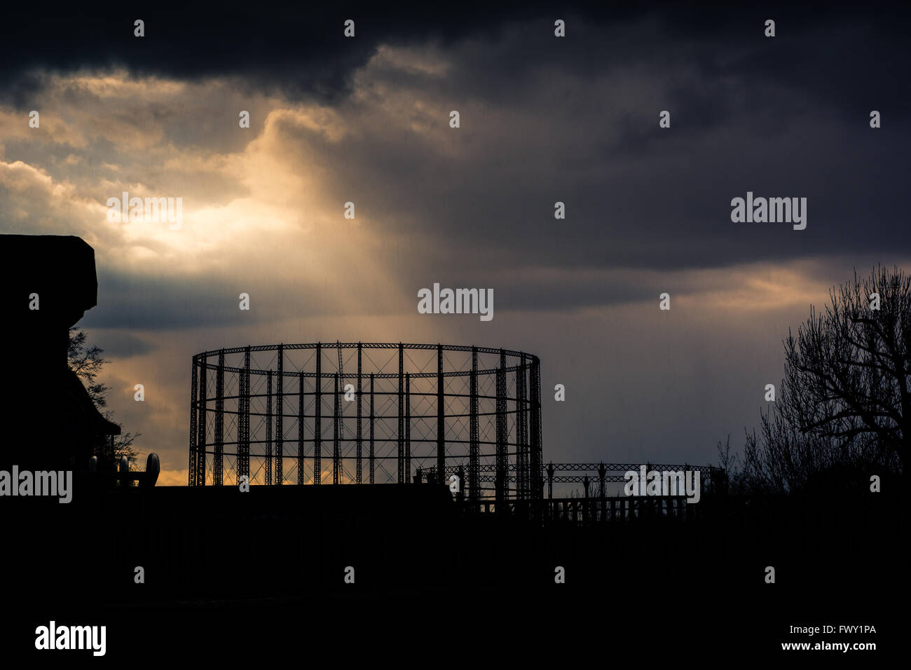 Kensal Green gasometer silhouetted in front of storm, part of the former Kensington Gas Works, in north-west London, England, UK Stock Photo