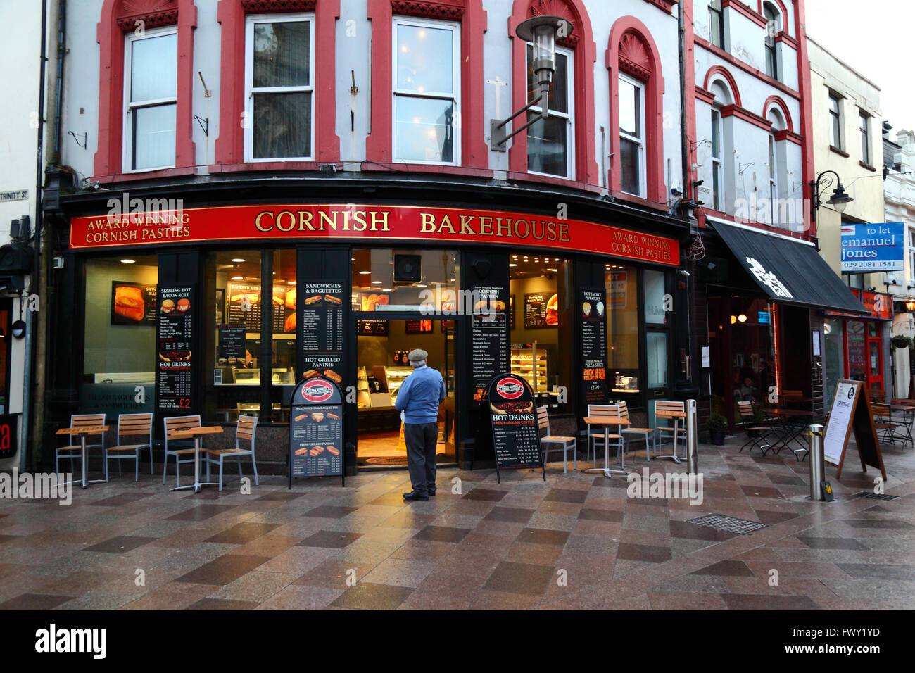 Man standing outside Cornish Bakehouse bakery / cafe looking at menu, Cardiff, South Glamorgan, Wales, United Kingdom Stock Photo