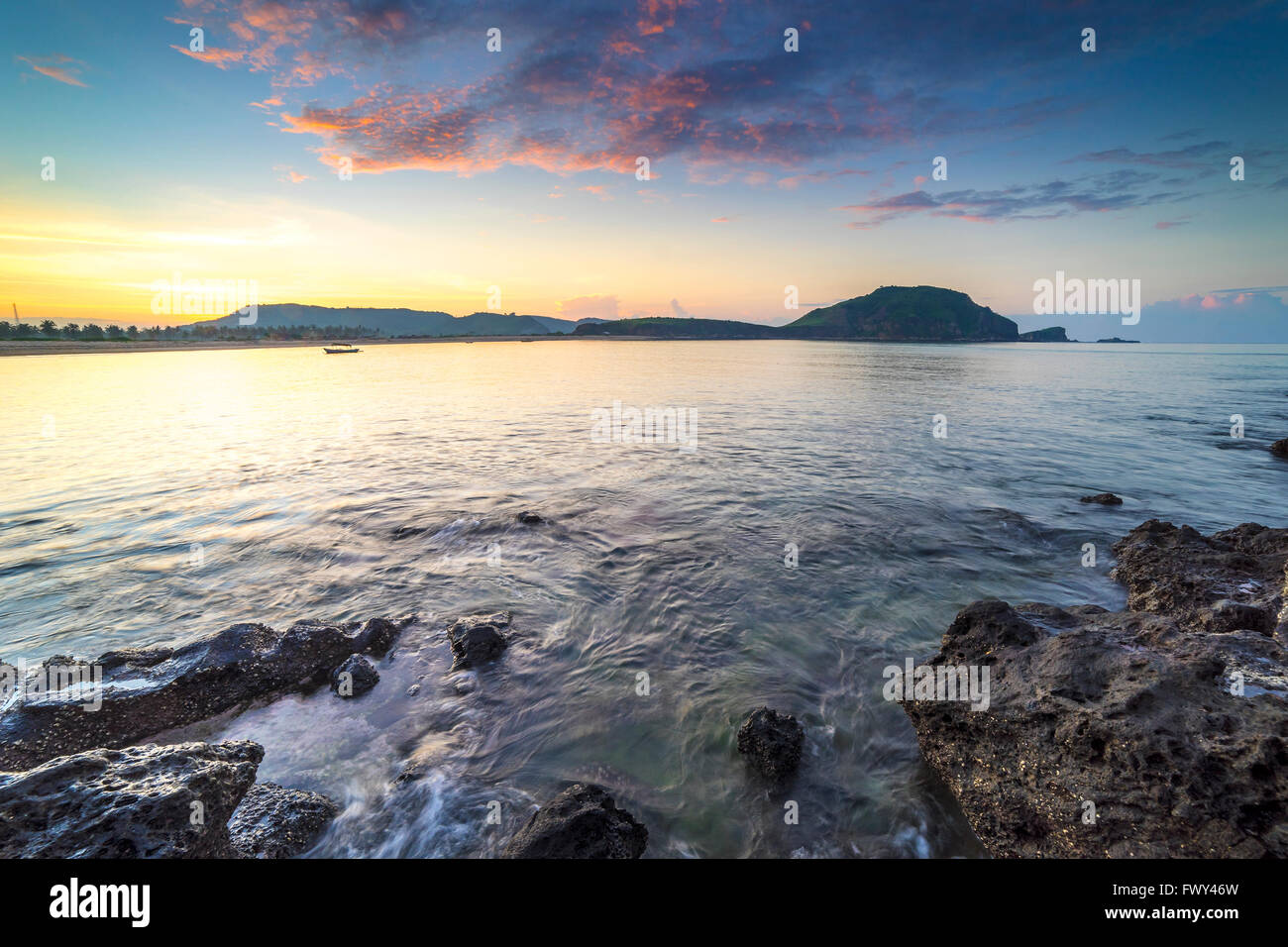 Beach rocks and water wave with sunset background Stock Photo - Alamy