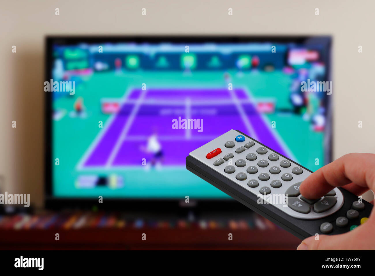 Watching a tennis match in the television, with a tv remote control in the  hand Stock Photo - Alamy