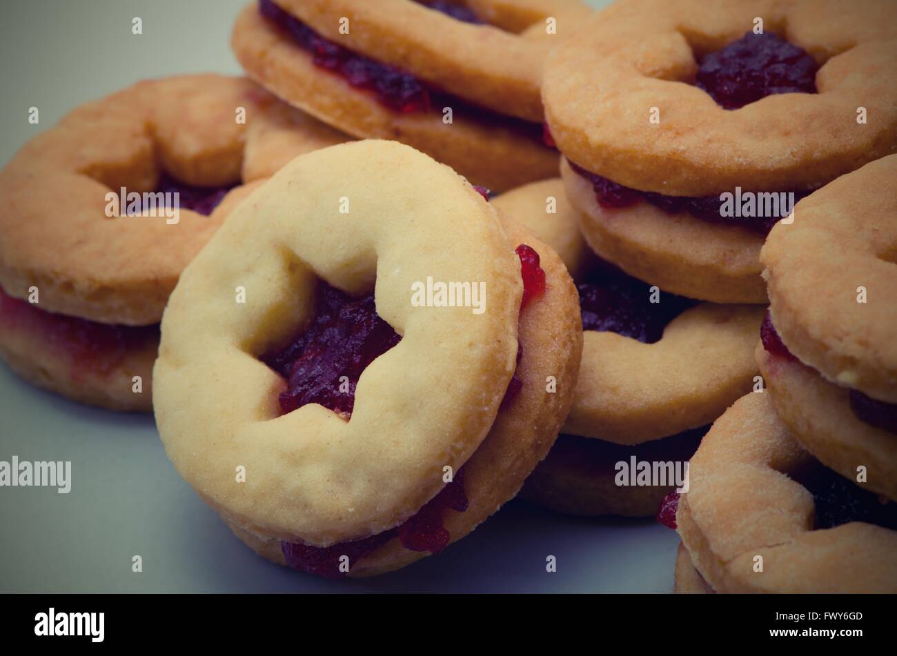 Round cookie with red jam in starshaped hole isolated on white
