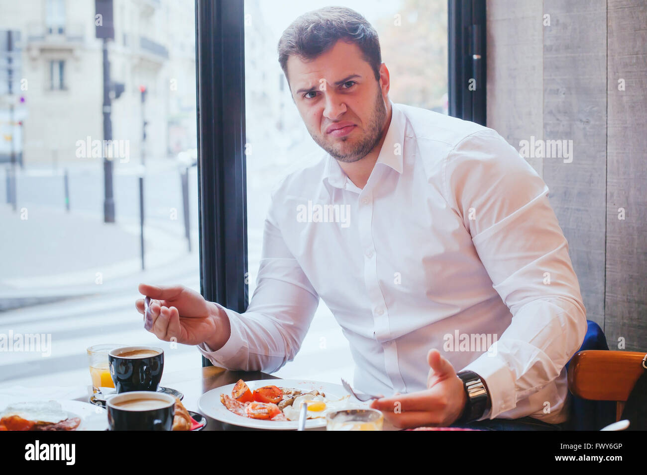 displeased angry customer in restaurant, man unhappy with food and bad service Stock Photo