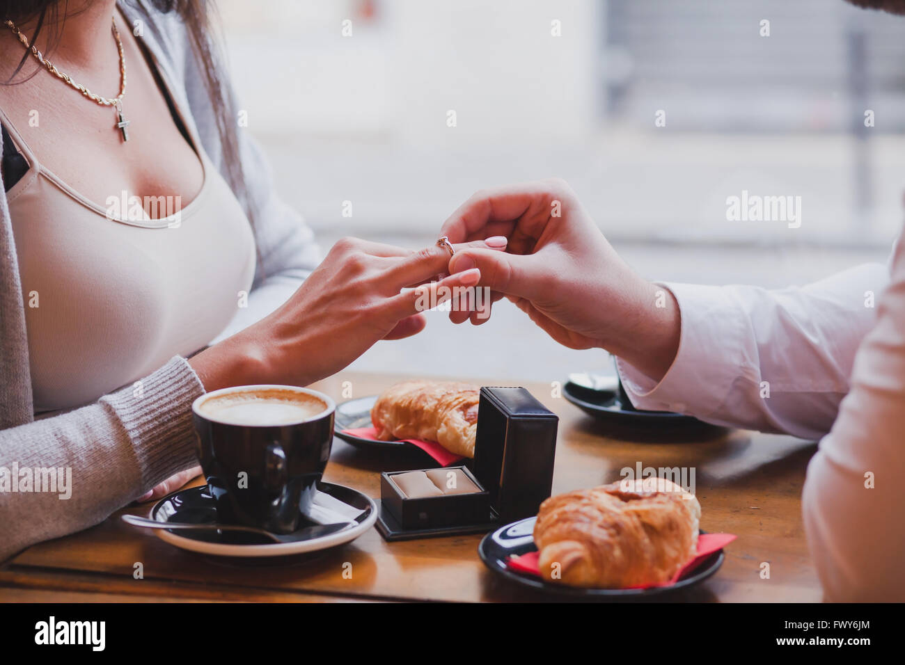 engagement ring, proposal in cafe, close up of hands of man and woman Stock Photo