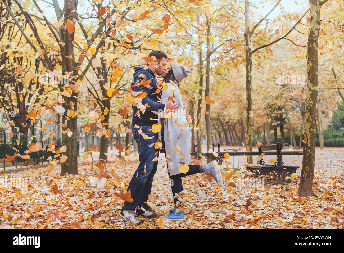 autumn kiss, young loving couple in the park with falling leaves Stock Photo