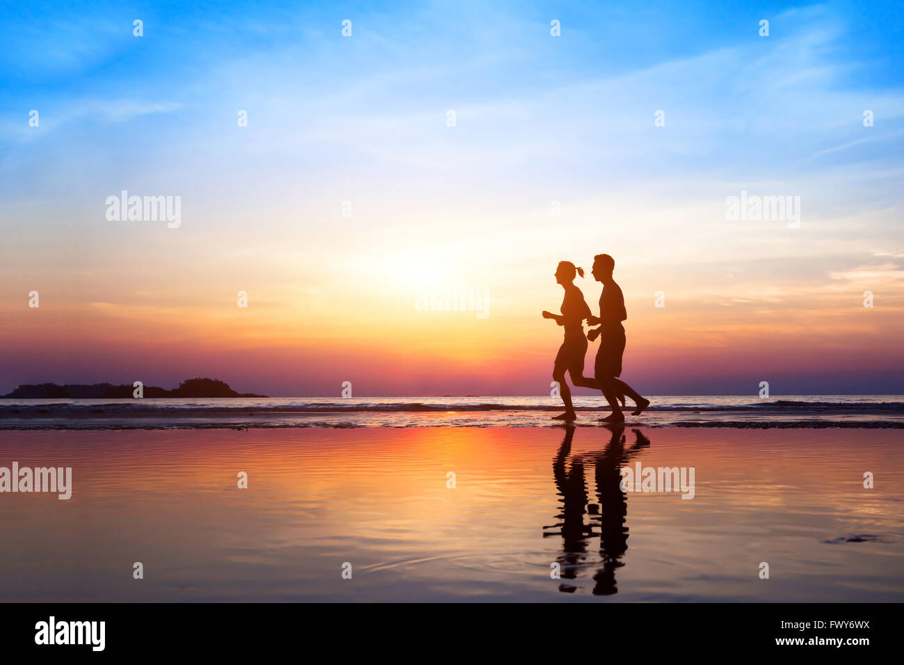 workout background, two people jogging on the beach at sunset, runners silhouettes, healthy lifestyle concept Stock Photo