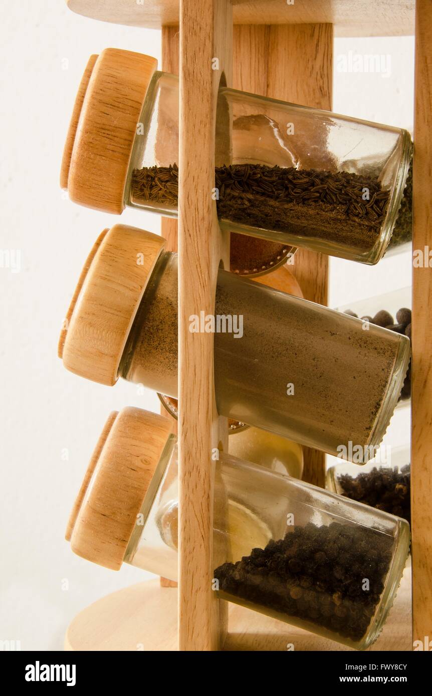 Wooden stand with spices in jars isolated on white background Stock