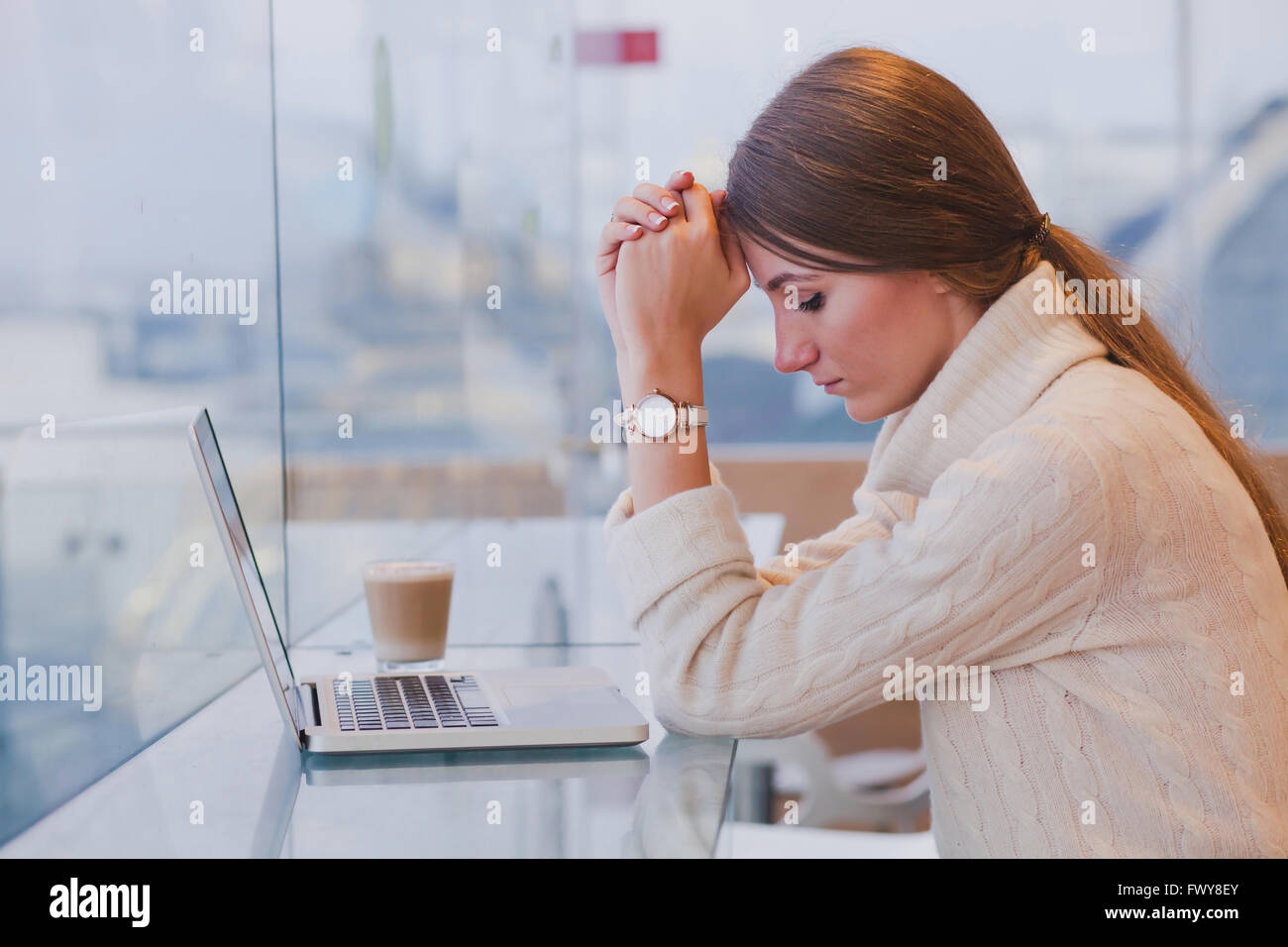 unemployment concept, problem, sad tired woman in front of laptop in modern bright cafe interior Stock Photo
