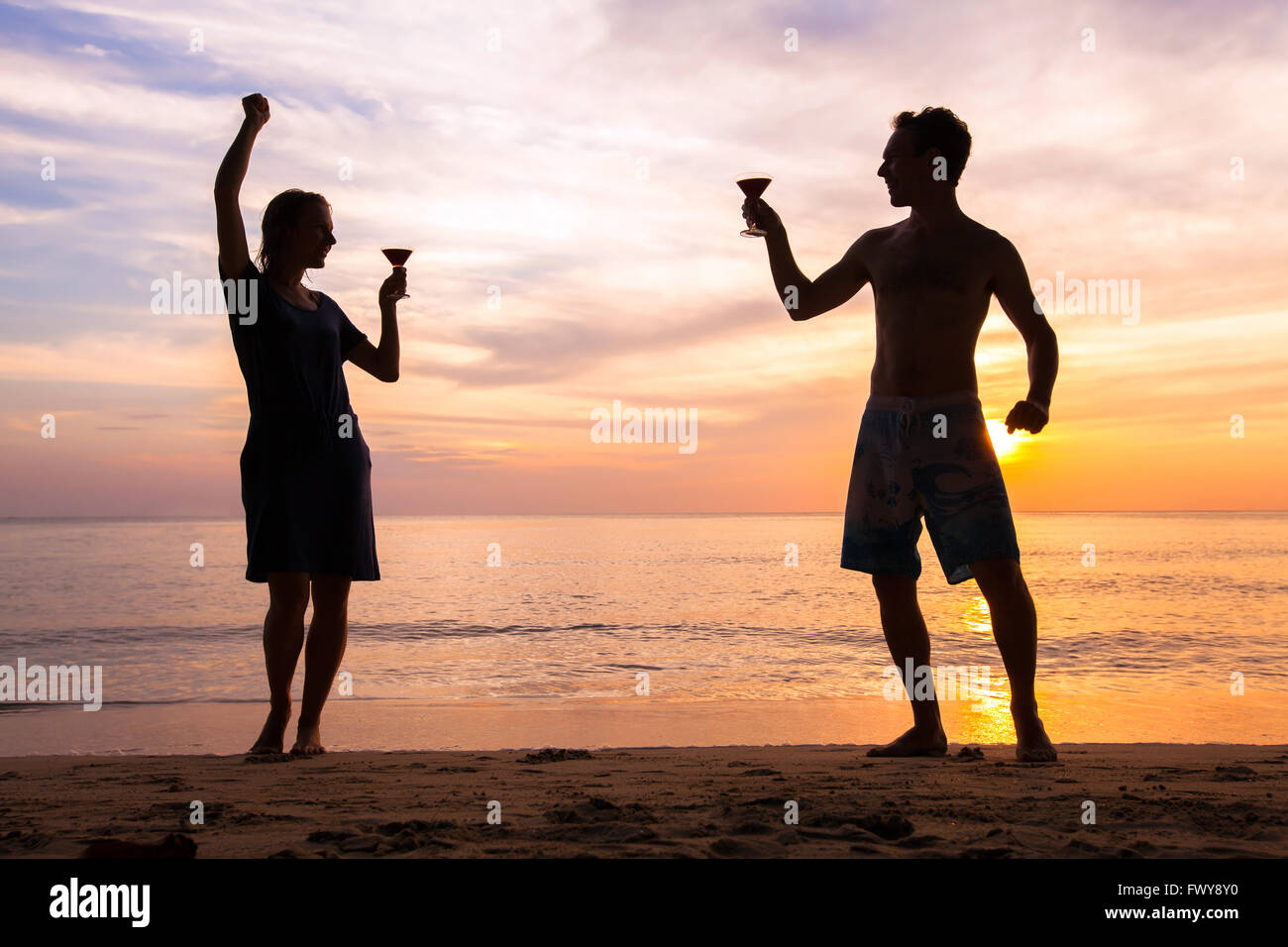 beach festival or party with friends, joyful happy people celebrating life, couple dancing with cocktails Stock Photo