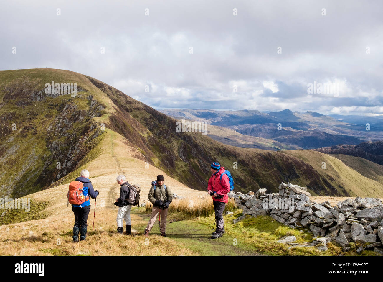 People hikers on Mynydd Talymignedd hiking towards col and Trum y