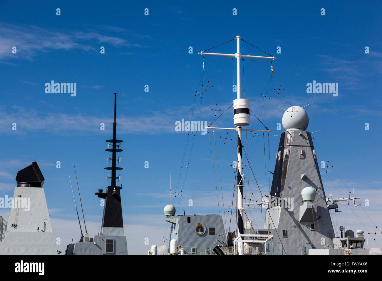The mast of HMS M33 rises in front of HMS Dauntless (D33) in the Royal Naval Dockyard, Portsmouth. Stock Photo