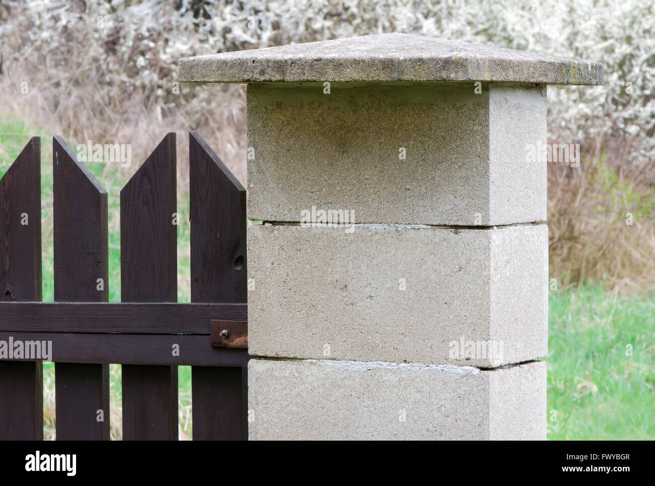 Concrete blocks side post of brown wooden fence Stock Photo Alamy