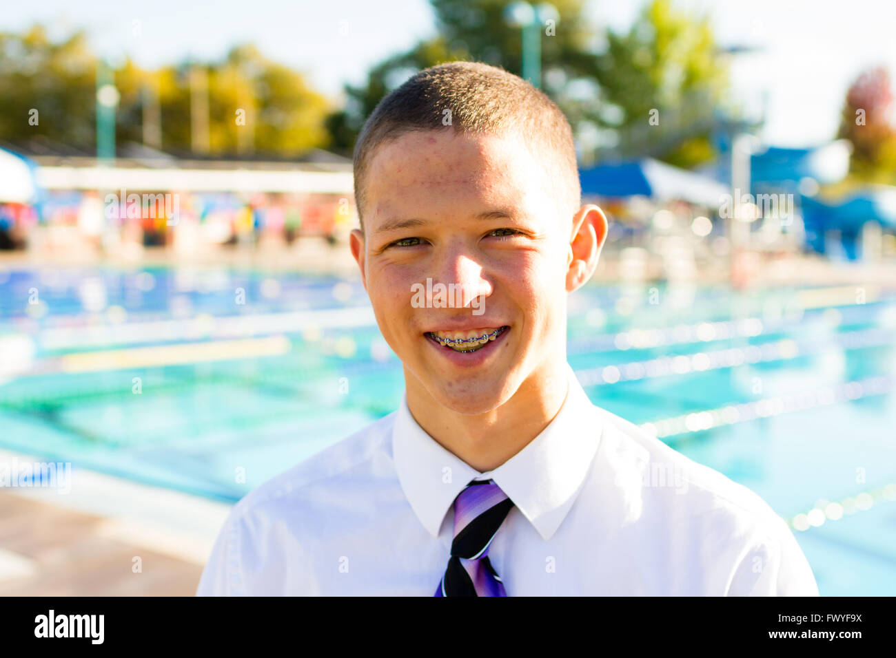 Senior photo portrait of a water polo athlete at an outdoor pool