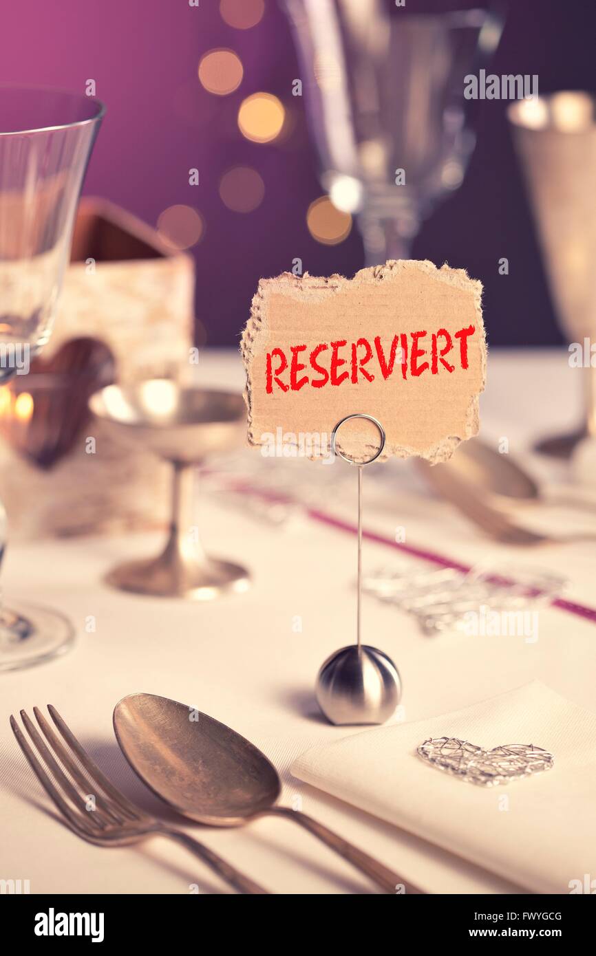Note on festive table with the inscription reserviert or reserved Stock Photo