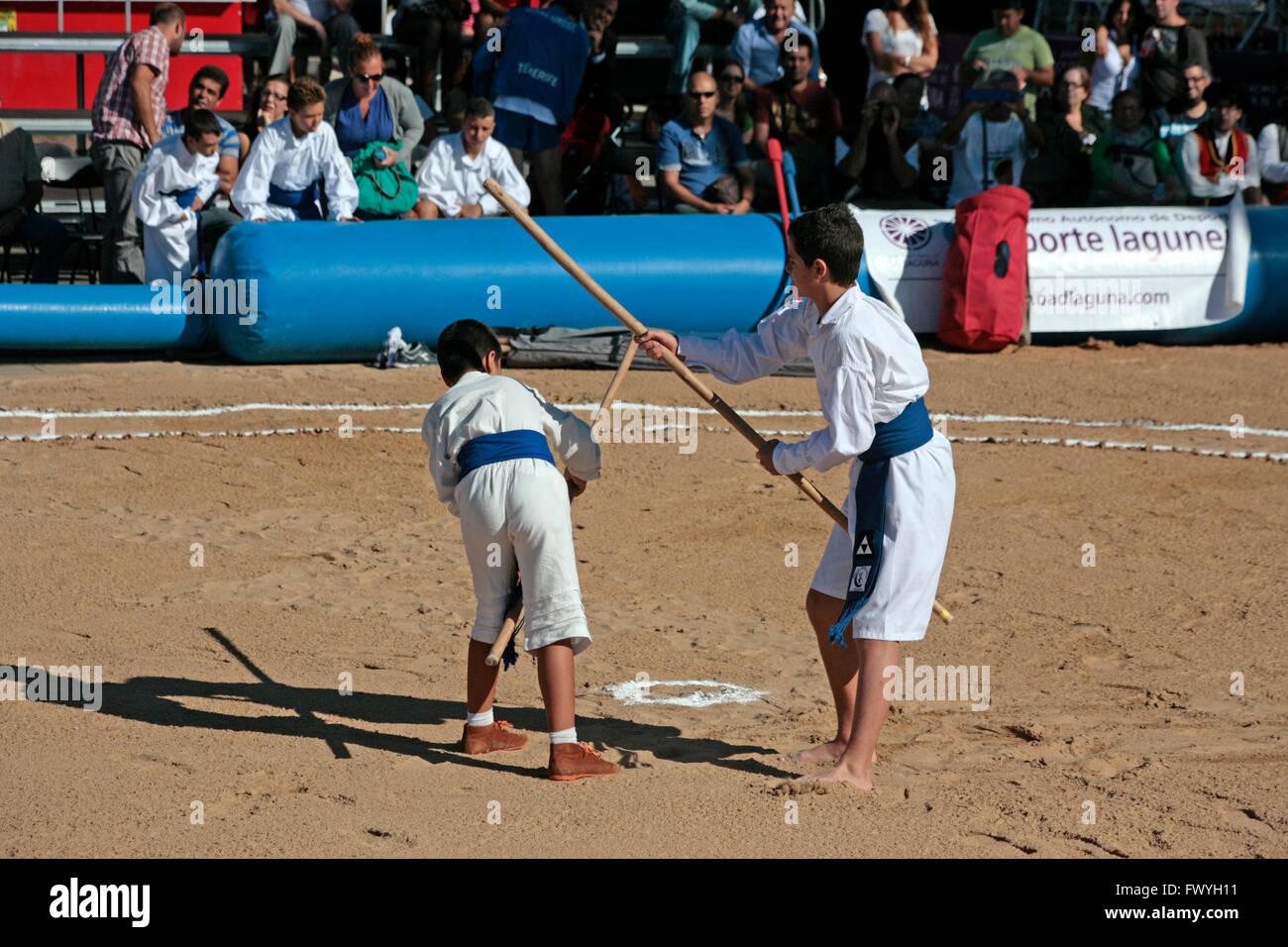 Teens playing the canarian stick wrestling in a public exhibition in the open air Stock Photo