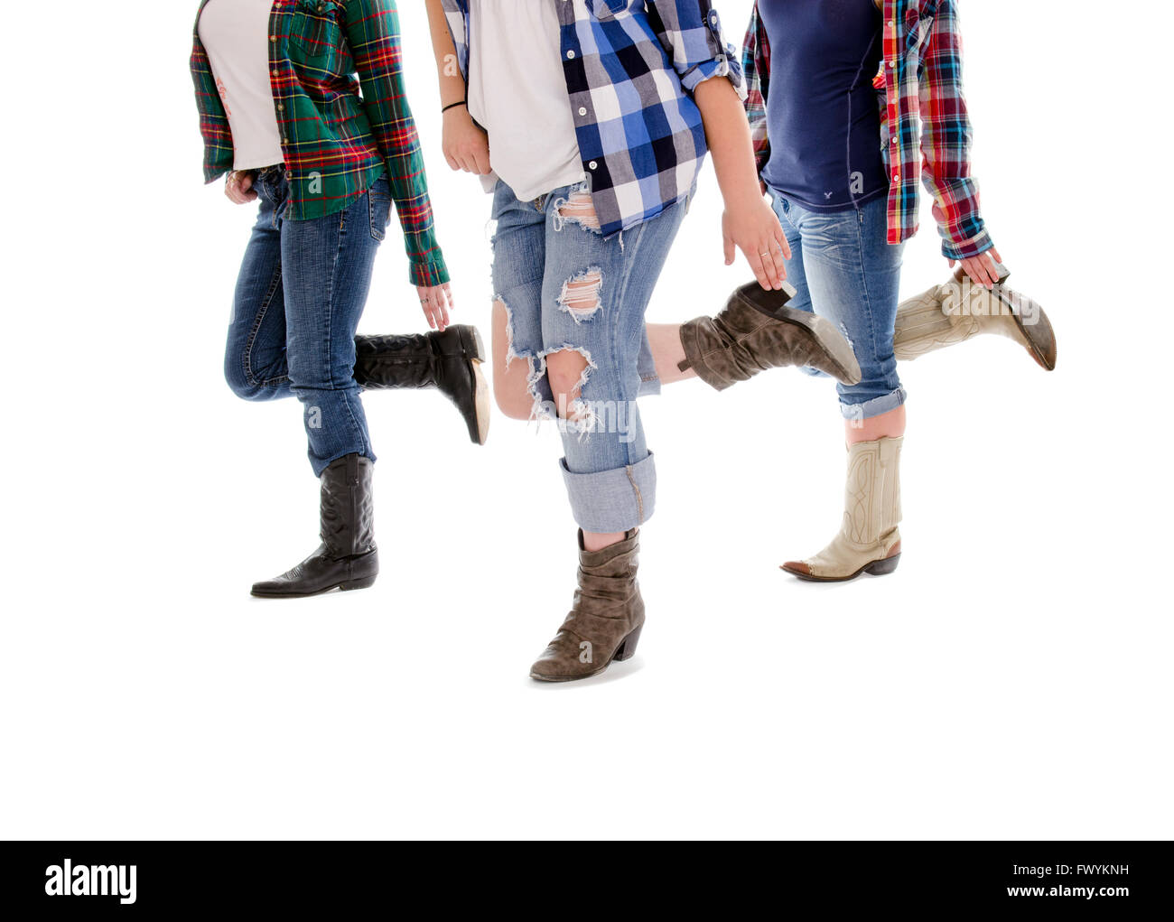 Legs of three women performing a line dance in cowboy boots and jeans. Stock Photo