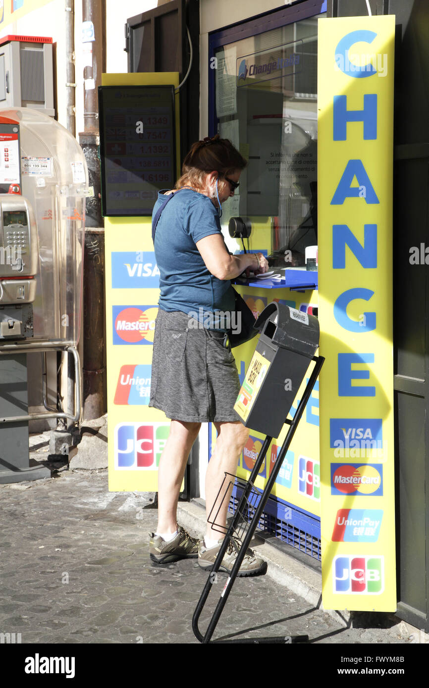 Woman tourist at money exchange office she changes his money in euros in the street of Rome, Italy. Stock Photo