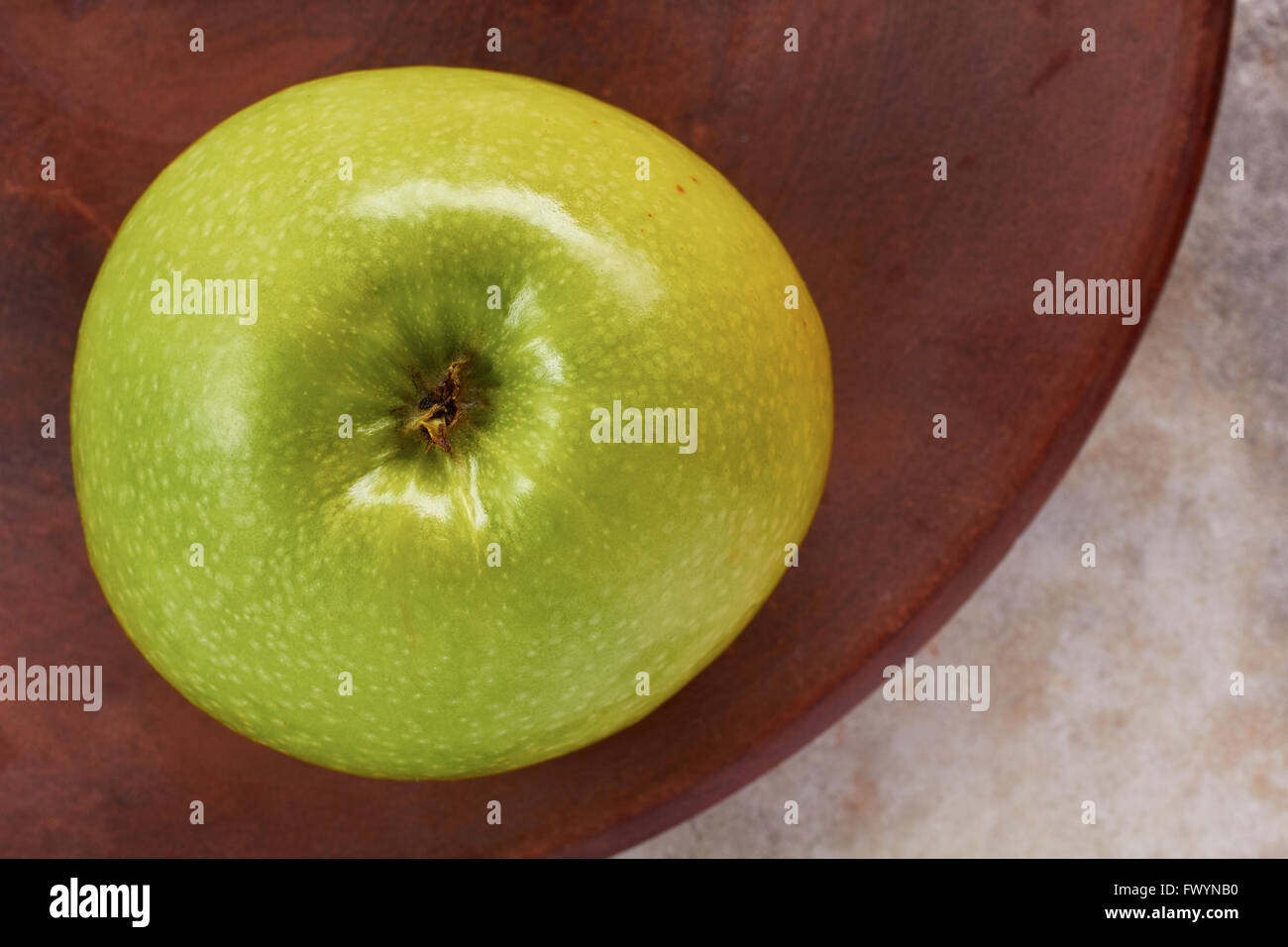 Fresh green apple on ceramic dish Stock Photo