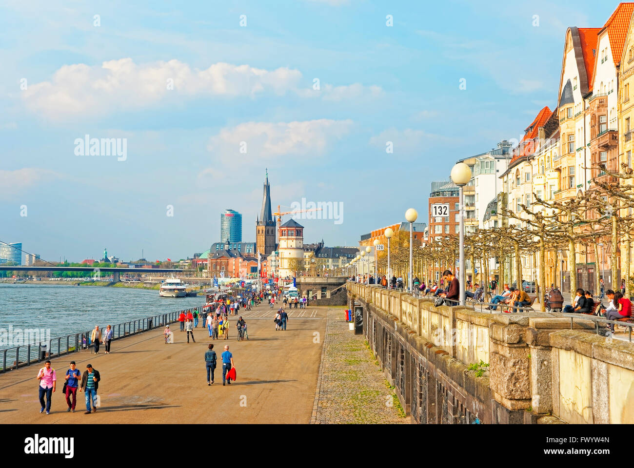 DUSSELDORF, GERMANY - MAY 3, 2013: Dusseldorf Rhine Embankmentr with tourists and St Lambertus Collegiate Church and Schiffahrtmuseum in the background. Stock Photo