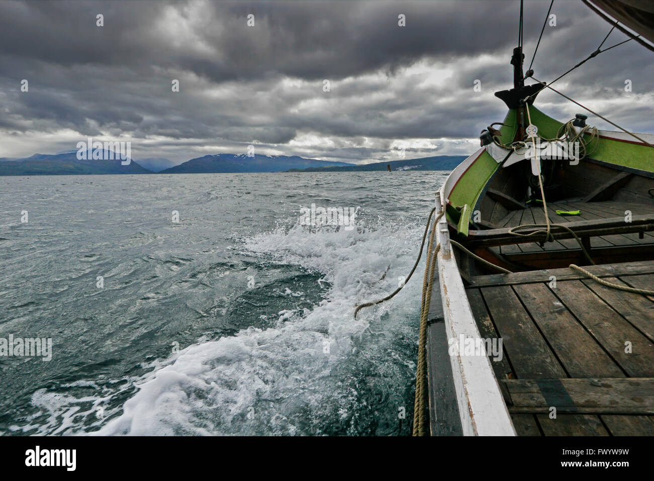A traditional wooden Nordland boat is sailing on Ofotfjorden in