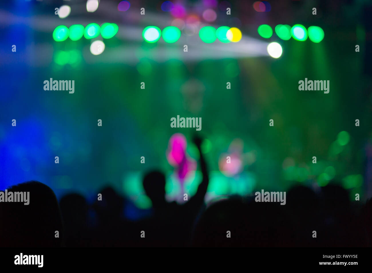 Blurred background : Club, disco DJ playing and mixing music for crowd of happy people. Nightlife, concert lights, flares Stock Photo
