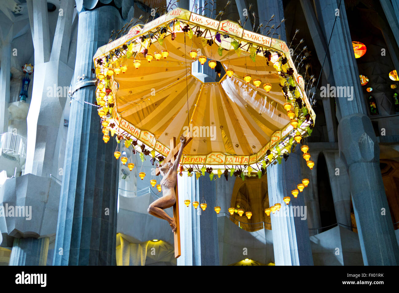 Inside the Sagrada Familia with a depiction of Christ on the cross at the altar, Barcelona, Spain Stock Photo