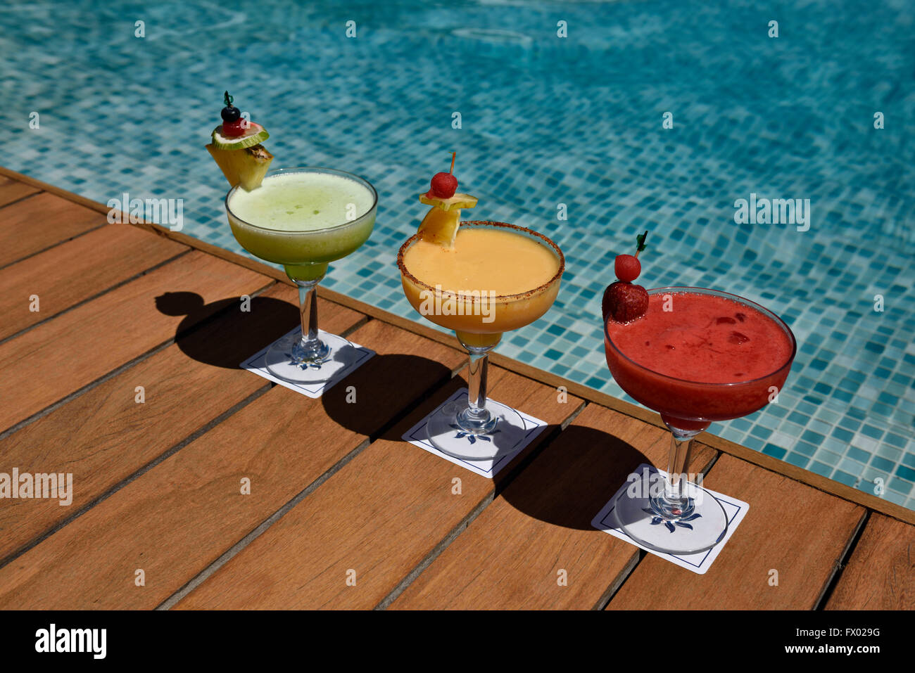 Three colorful alcoholic drinks on a deck next to a pool in Nuevo Vallarta Mexico Stock Photo