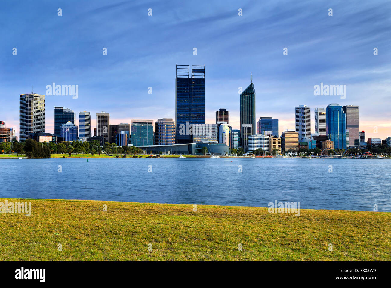 Green grass accross from Perth city CBD over Swan River in Western Australia at sunrise. Stock Photo