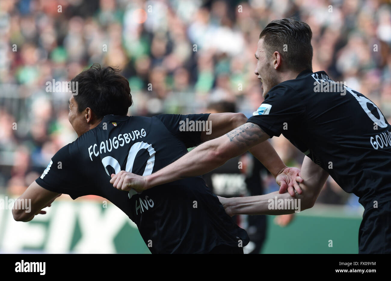 Bremen, Germany. 09th Apr, 2016. Augsburg's Jeong-Ho Hong celebrates his 1-2 goal with Jeffrey Gouweleeuw (R) during the German Bundesliga soccer match between Werder Bremen and FC Augsburg in the Weser Stadium in Bremen, Germany, 09 April 2016. Photo: CARMEN JASPERSEN/dpa (EMBARGO CONDITIONS - ATTENTION - Due to the accreditation guidelines, the DFL only permits the publication and utilisation of up to 15 pictures per match on the internet and in online media during the match)/dpa/Alamy Live News Stock Photo