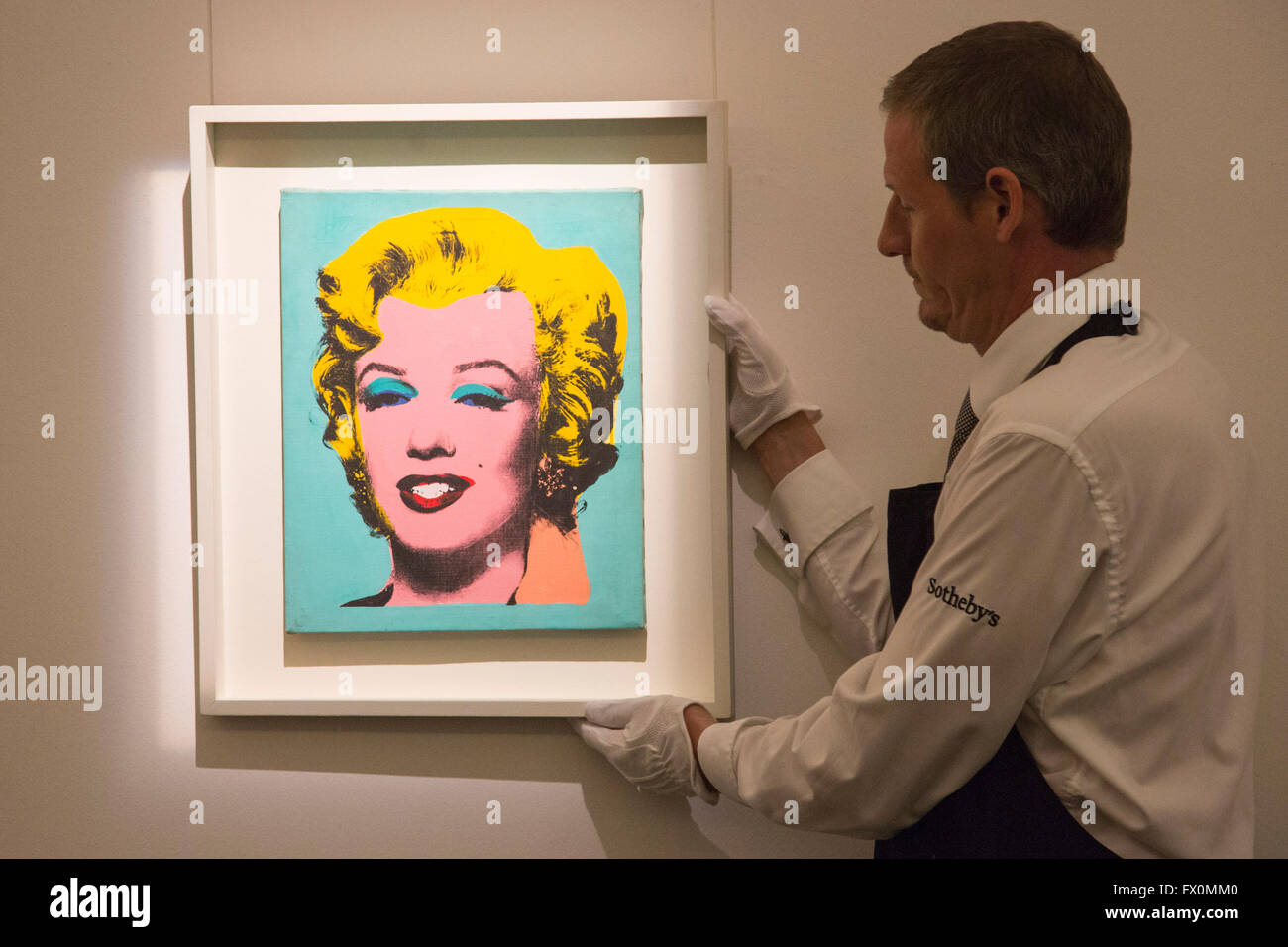 London, UK. 8 April 2016. A Sotheby's employee handles the artwork Warhol's Marilyn Monroe, 1967, by Elaine Sturtevant, known as the Queen of Copycats. Estimate: USD 300,000-400,000.  Sotheby's London Auction Preview of art from the Contemporary Art Evening Auction in New York on 11 May 2016. Stock Photo