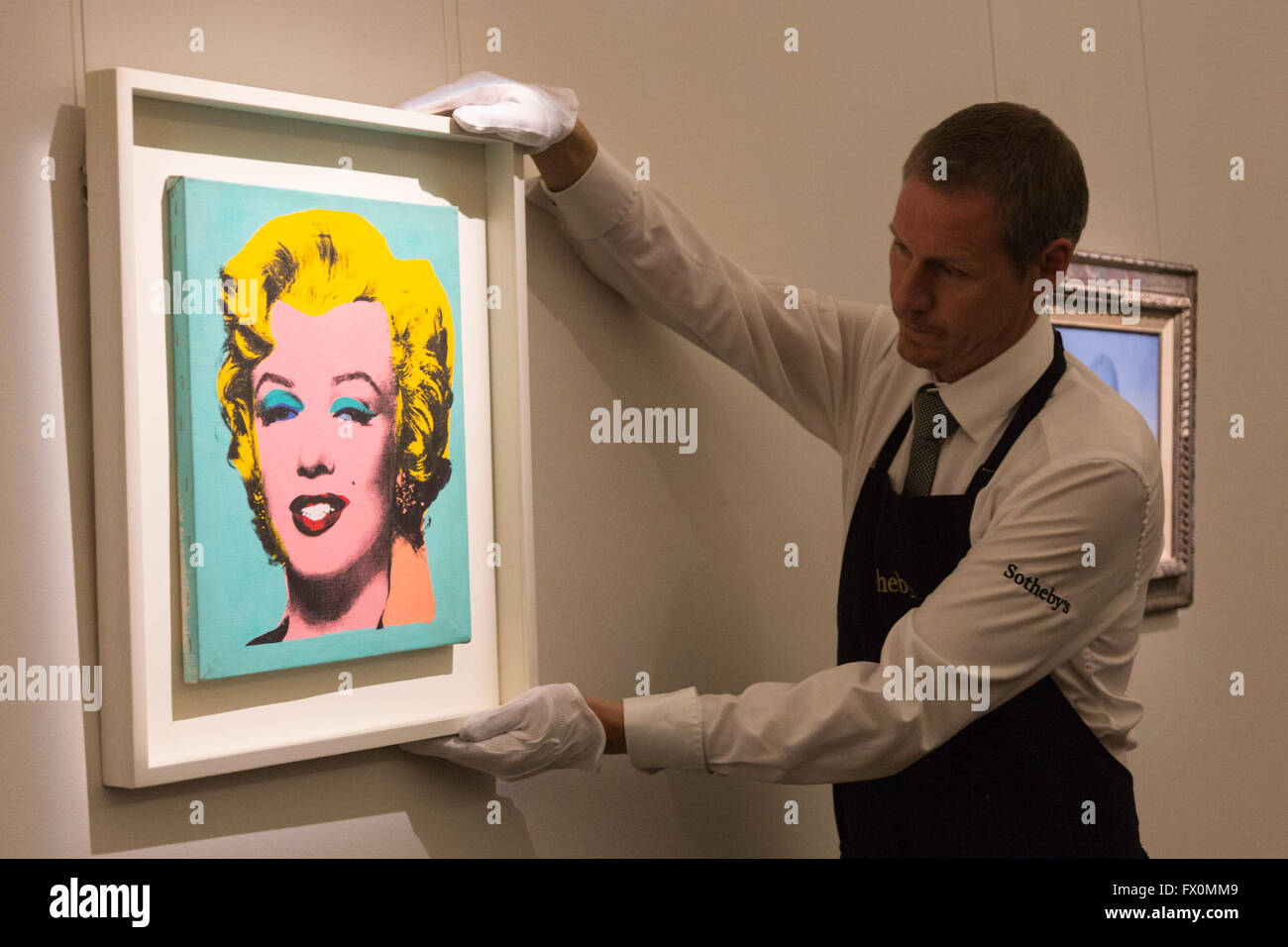 London, UK. 8 April 2016. A Sotheby's employee handles the artwork Warhol's Marilyn Monroe, 1967, by Elaine Sturtevant, known as the Queen of Copycats. Estimate: USD 300,000-400,000.  Sotheby's London Auction Preview of art from the Contemporary Art Evening Auction in New York on 11 May 2016. Stock Photo