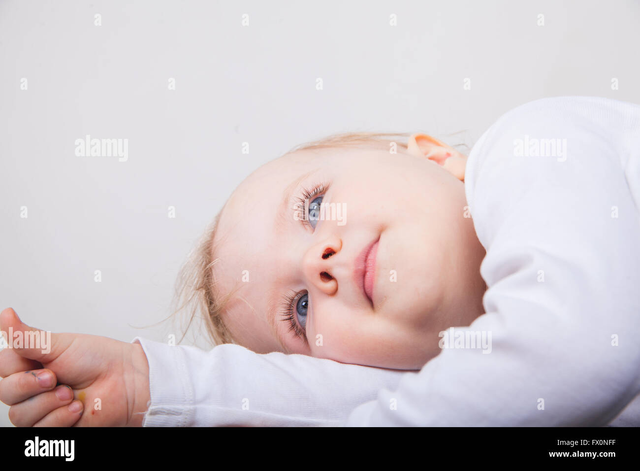 Cute baby girl lying on white background Stock Photo - Alamy