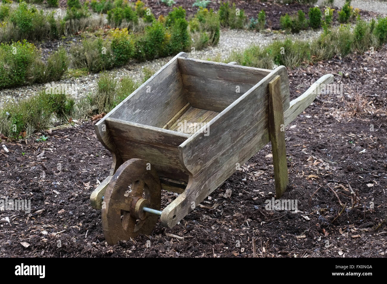 Old wooden wheelbarrow in large garden. Stock Photo
