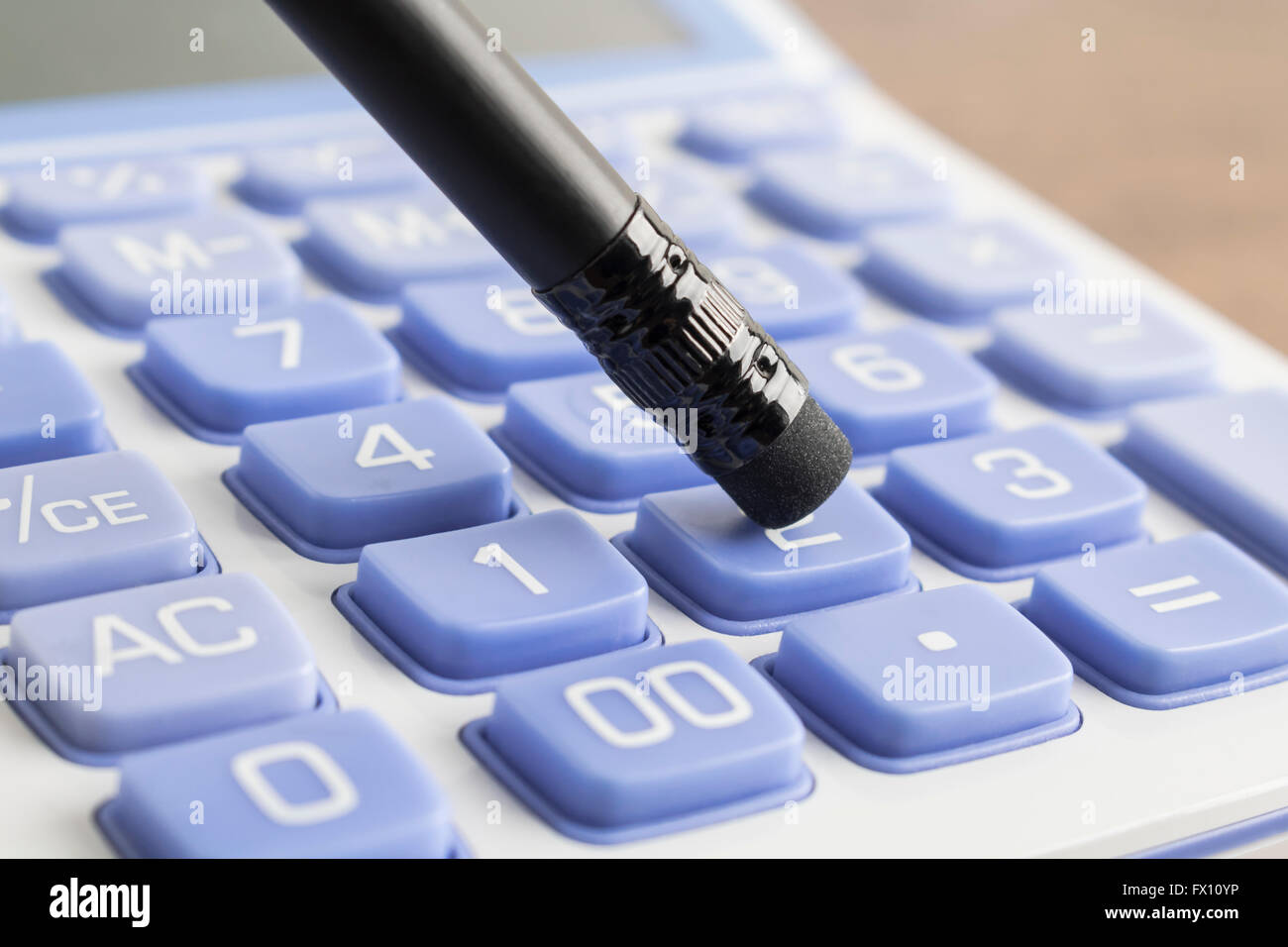 Pushing calculator number button with pencil Stock Photo