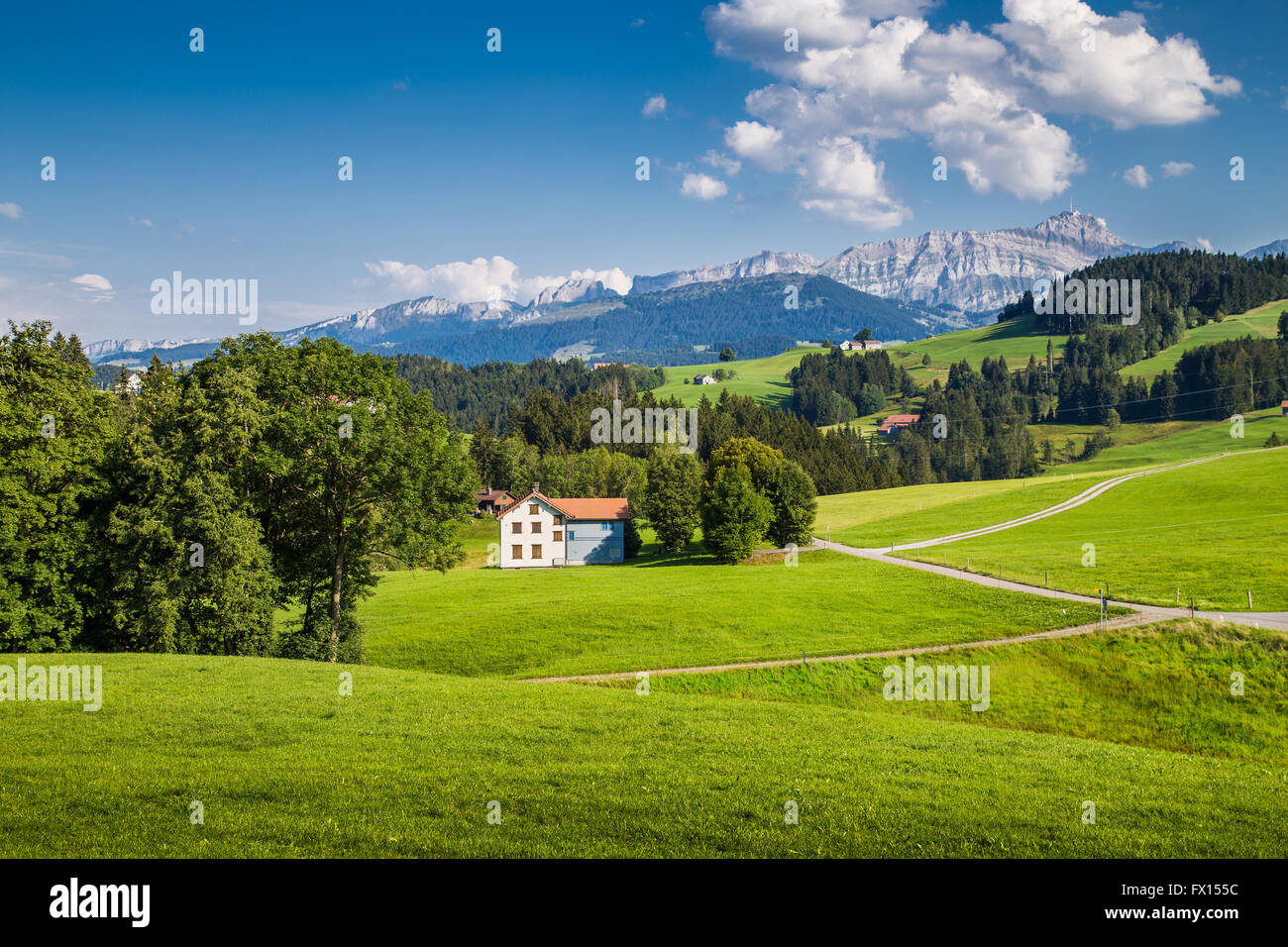 Idyllic landscape in the Alps with green meadows and famous Saentis mountain top in the background, Appenzellerland, Switzerland Stock Photo