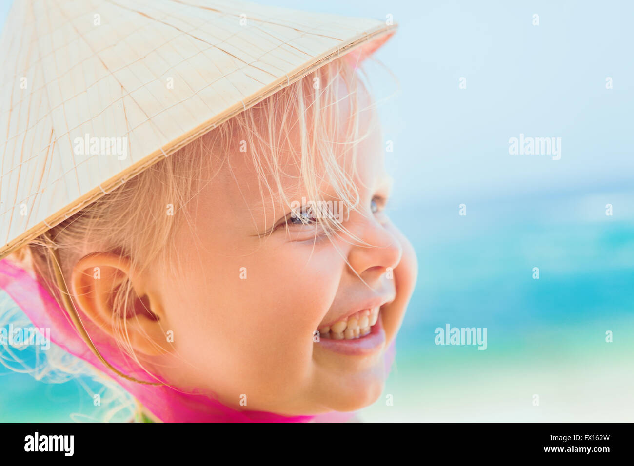 Portrait of beautiful little traveler on sunny white sand beach happy
