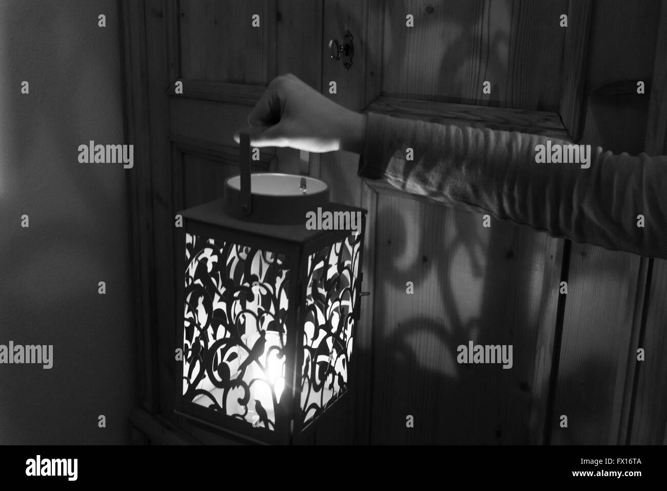 Monochrome black and white image - woman holding up a lantern that is ...