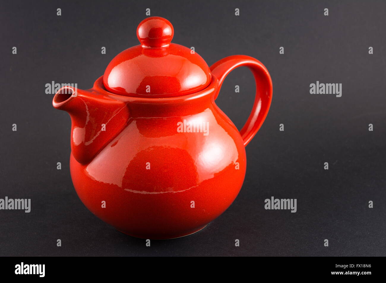 Read shiny teapot on black background Stock Photo