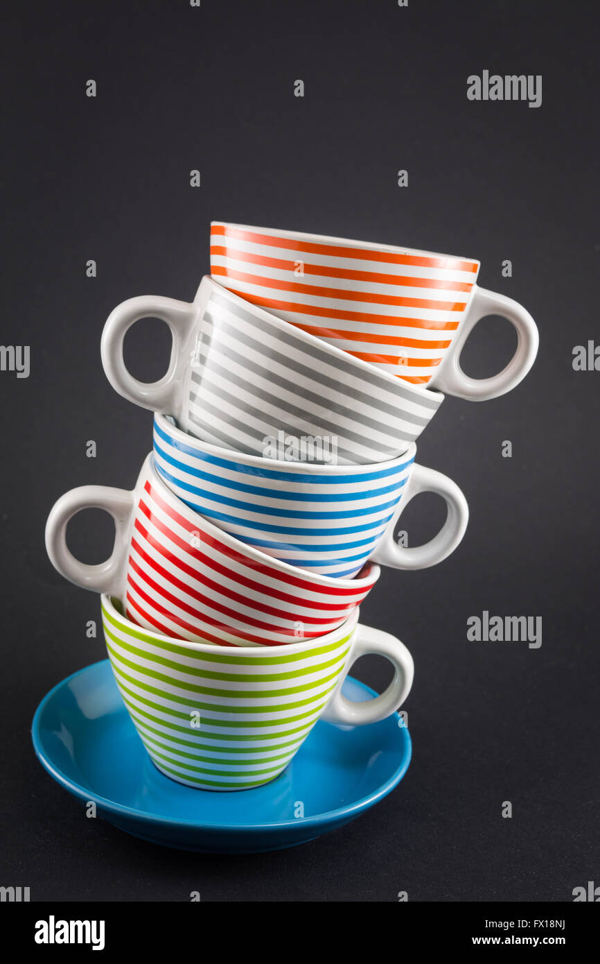 Four tea cups stacked on black background Stock Photo