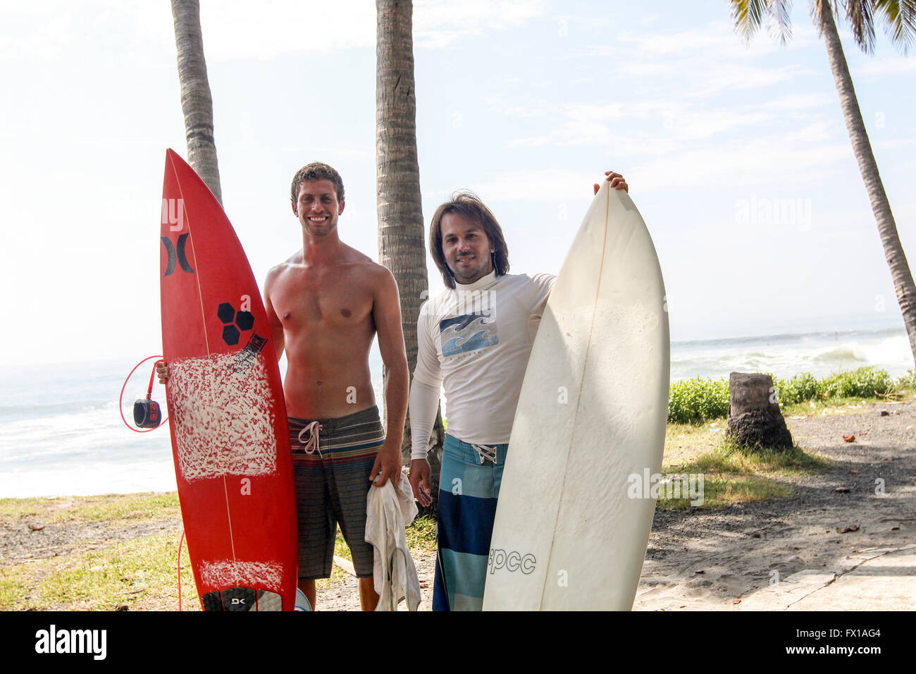Two surfers with surfboards photographed at El Tunco beach, El Salvador Stock Photo