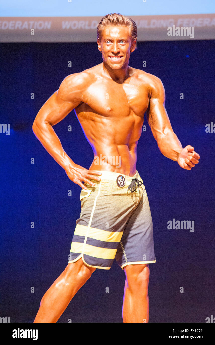 MAASTRICHT, THE NETHERLANDS - OCTOBER 25, 2015: Male physique model shows his best side pose at championship on stage Stock Photo