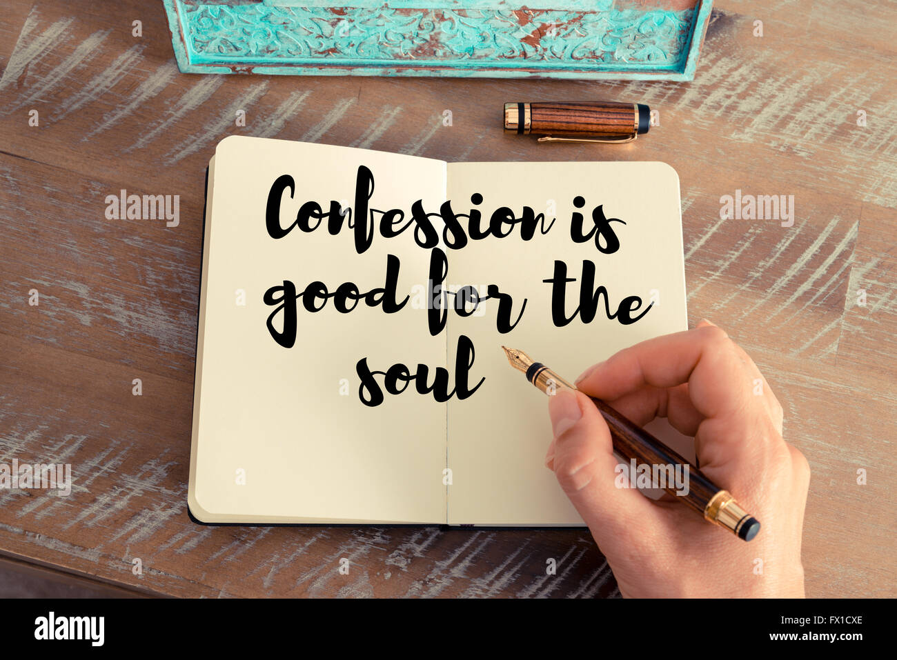 Retro effect and toned image of a woman hand writing on a notebook. Handwritten quote Confession is good for the soul as inspirational concept image Stock Photo
