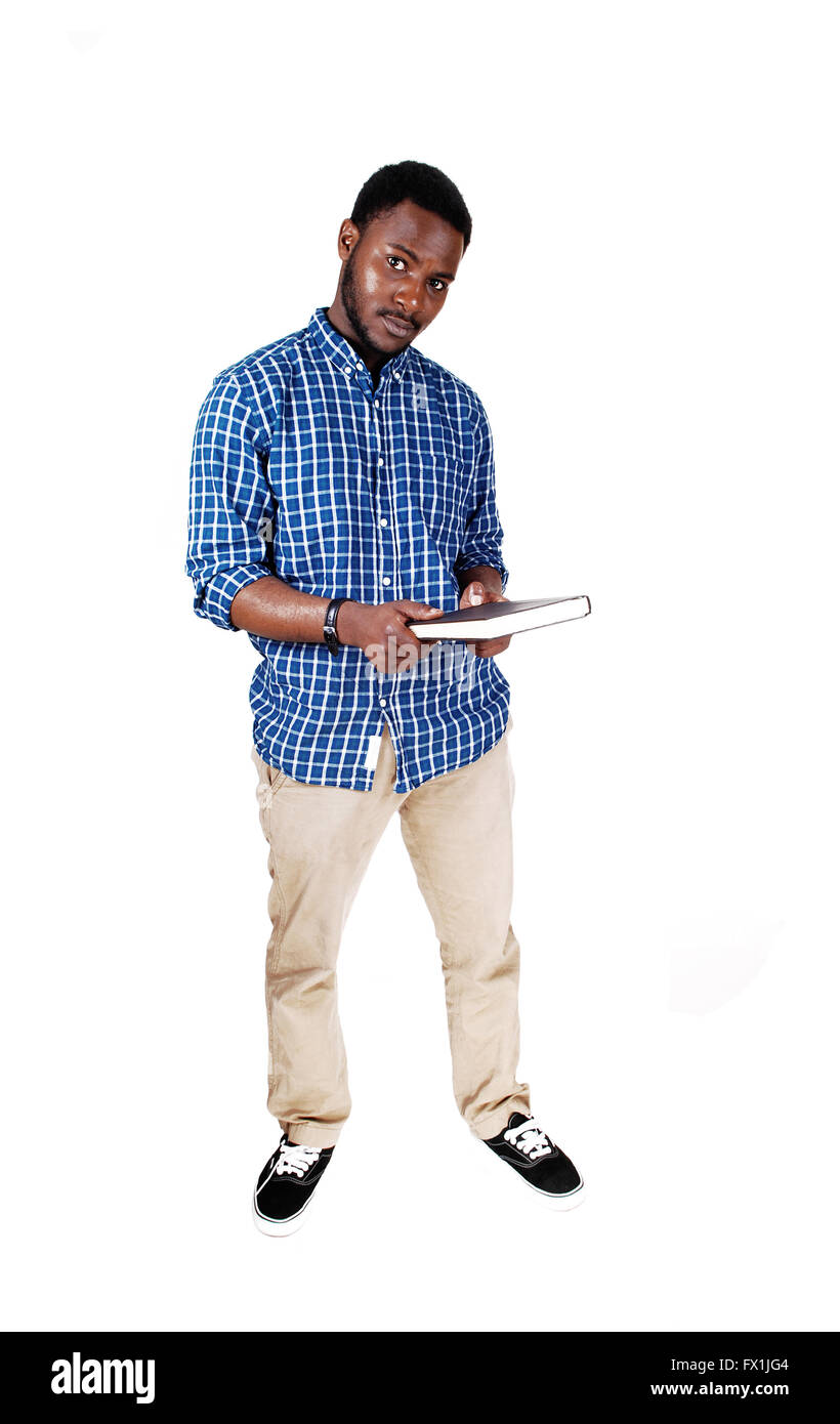A protract picture of a black man in a blue shirt standing and holding a book  in his hands, isolated for white background. Stock Photo