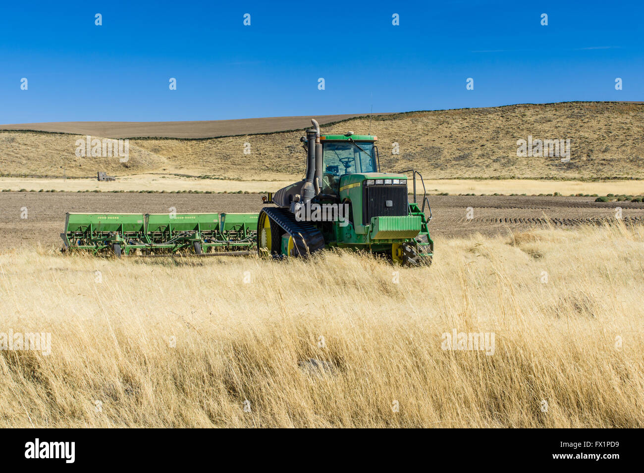 John Deere tractor with planter in a field in eastern Washington Stock Photo