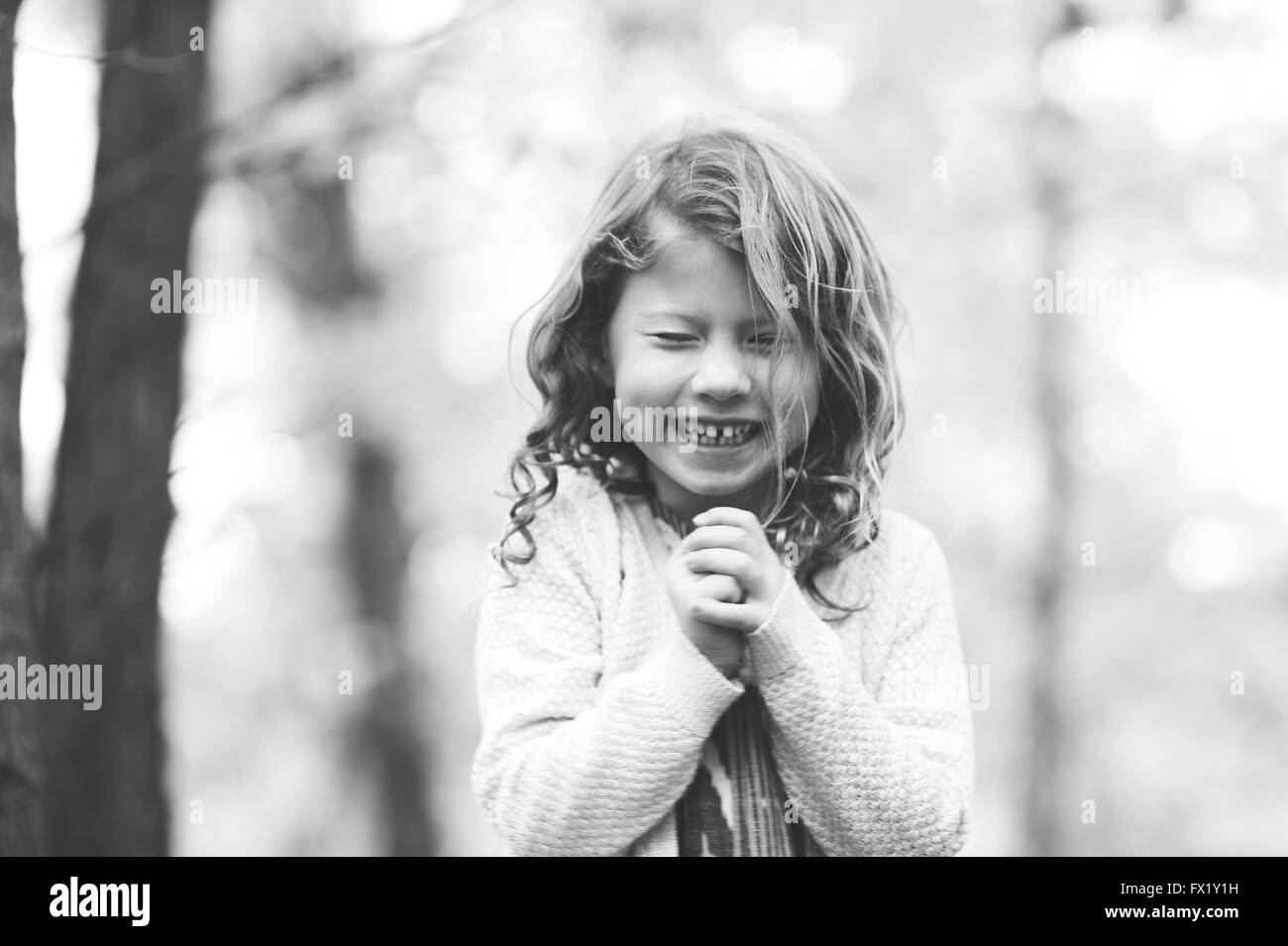 Black and white image of a girl laughing with her eyes shut. Stock Photo