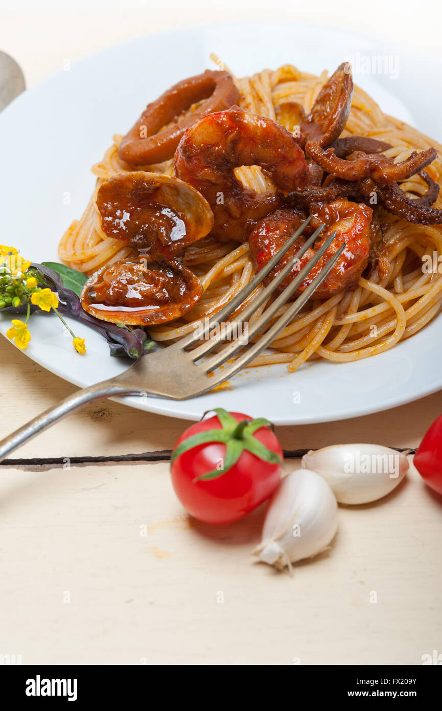 Rustic presentation of spaghetti topped with clams and calamari in a light tomato-based sauce.