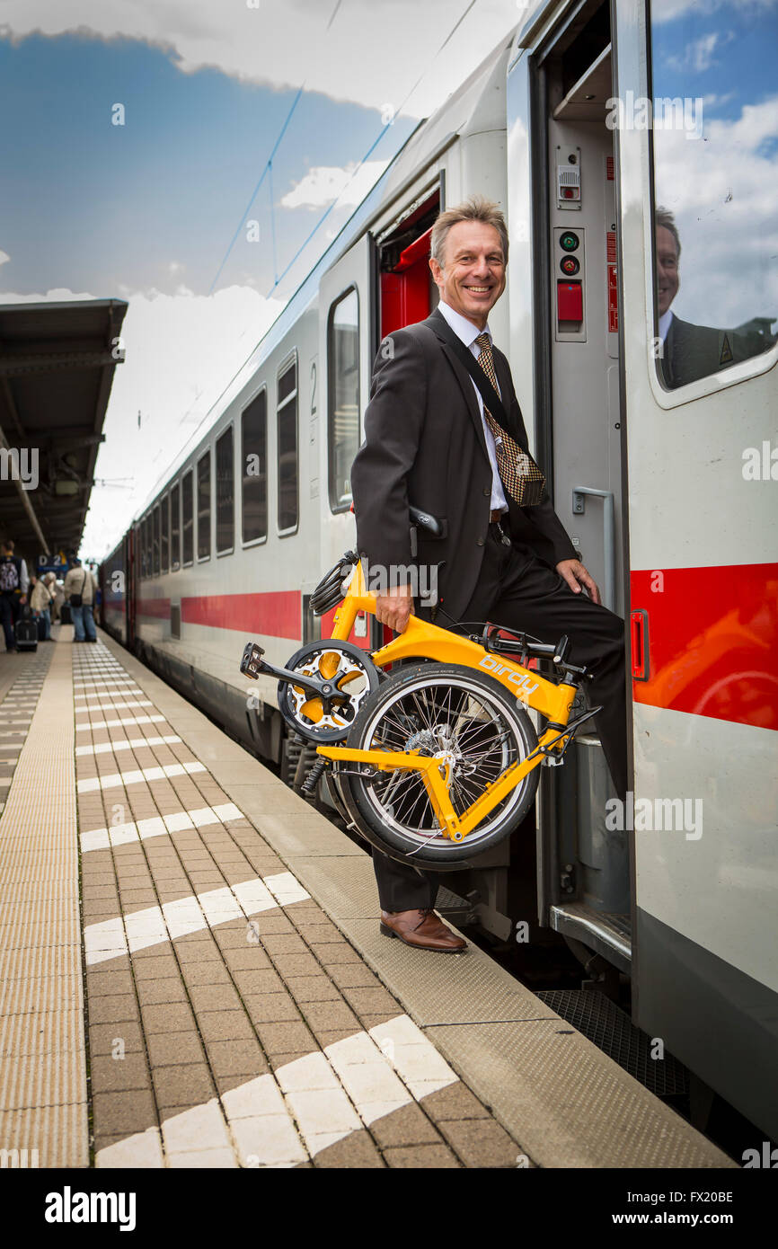 Businessman with folding bike gets into the train Stock Photo Alamy