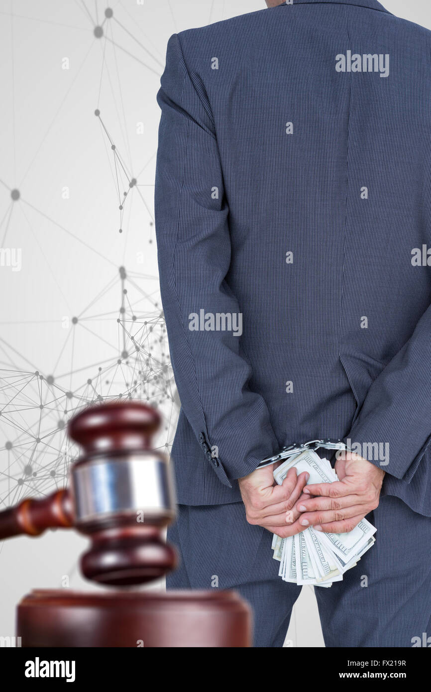 Composite image of rear view of businessman with handcuff and banknotes Stock Photo