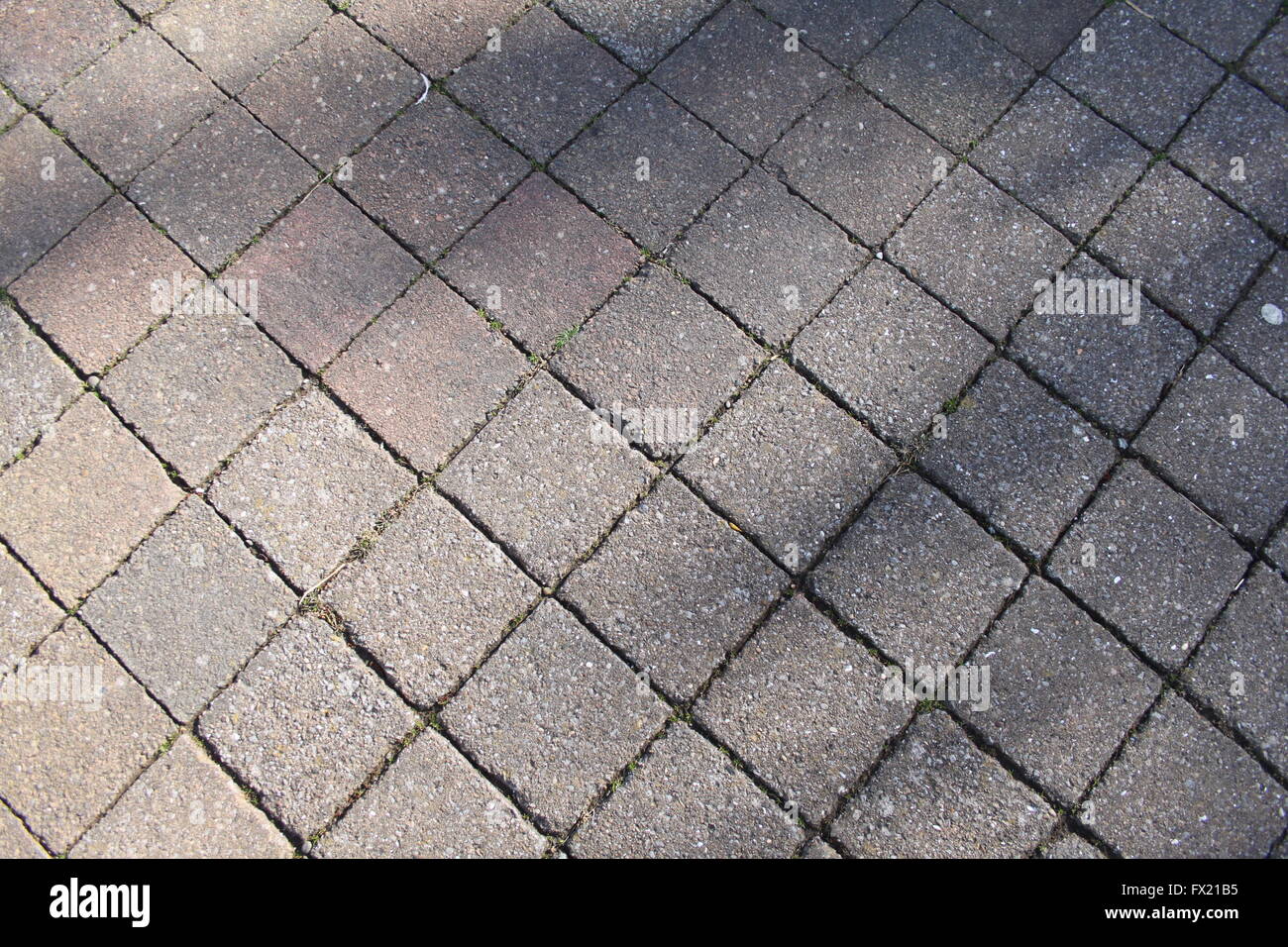 Skewed wide shot of square block paving stones showing shadow and perspective to add interest Stock Photo