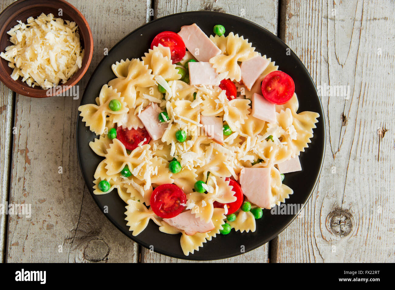 Pasta with ham and green peas tomato cheese Stock Photo